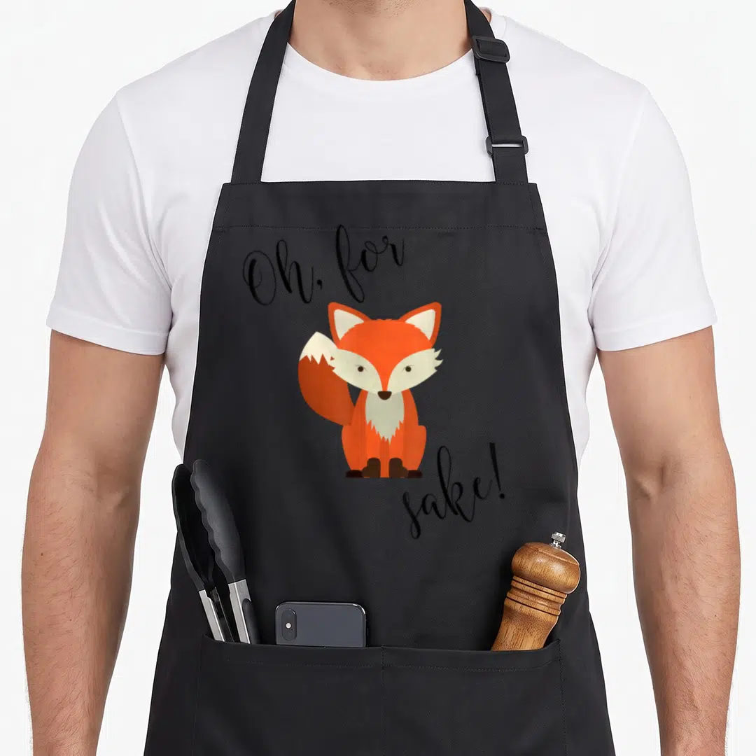 Sake fox print apron - Orange cartoon fox with Oh for sake text on black apron — shown on a black cotton canvas apron against a white background