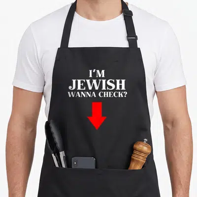 Check jewish apron - I'M JEWISH WANNA CHECK? text and red arrow pointing down — shown on a black cotton canvas apron against a white background