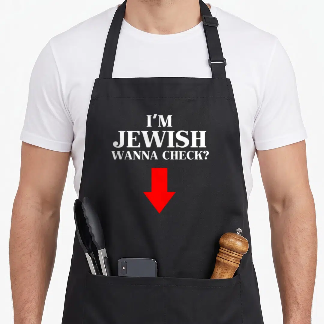 Check jewish apron - I'M JEWISH WANNA CHECK? text and red arrow pointing down — shown on a black cotton canvas apron against a white background