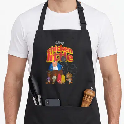 Character chicken apron - Retro cartoon graphic with red and yellow text above a pig, grey alien, and smaller animals — shown on a black cotton canvas apron against a white background