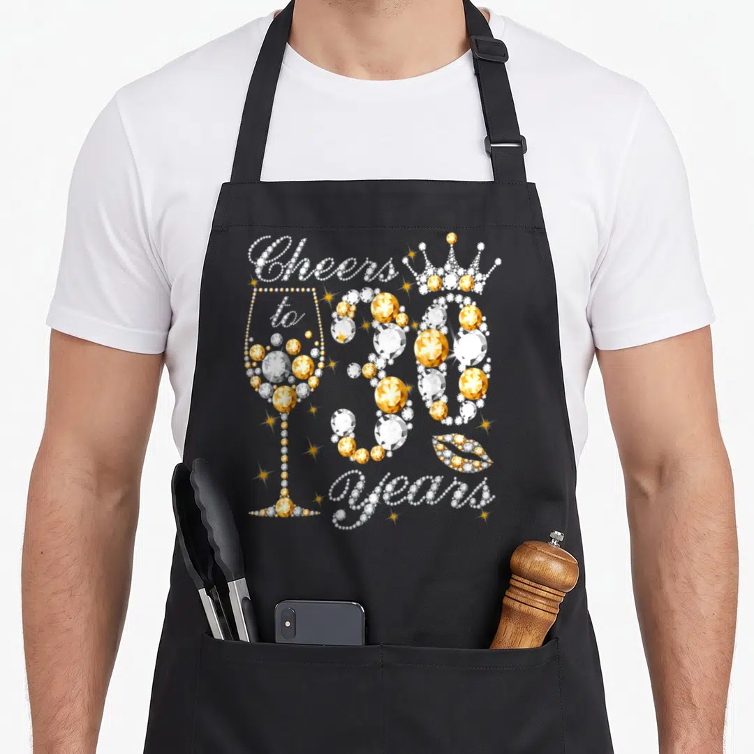 30th wine apron - Gold and white rhinestone text Cheers to 30 Years with champagne glass, crown, and lips — shown on a black cotton canvas apron against a white background