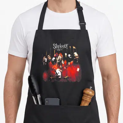 Slipknot crew apron - Distressed graphic of masked figures in red jumpsuits with white Slipknot text — shown on a black cotton canvas apron against a white background