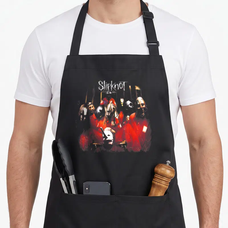 Slipknot crew apron - Distressed graphic of masked figures in red jumpsuits with white Slipknot text — shown on a black cotton canvas apron against a white background