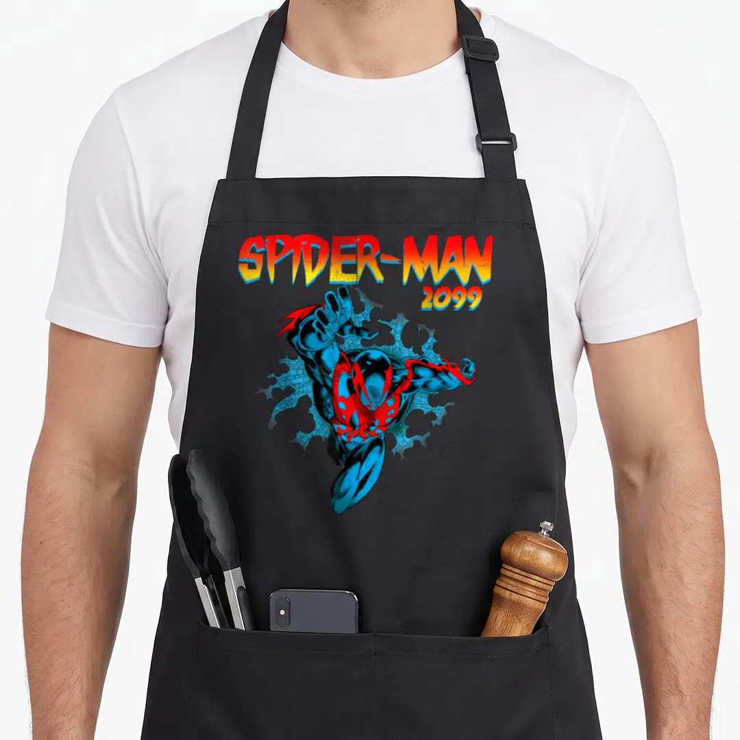 Jump spider apron - Spider-Man 2099 leaping through blue brick wall with gradient text — shown on a black cotton canvas apron against a white background