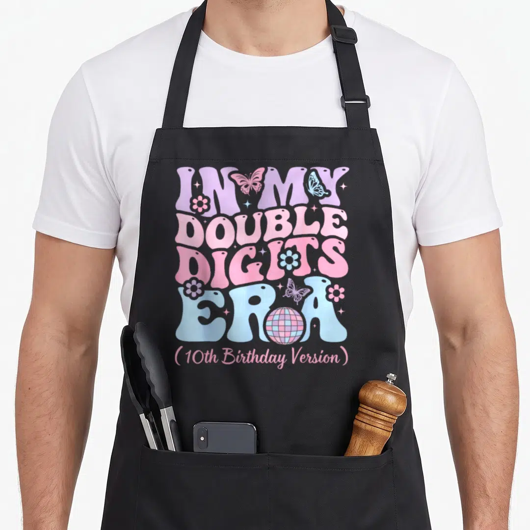 Era 10th birthday apron - Bubble text reading In My Double Digits Era with butterflies and a disco ball inside — shown on a black cotton canvas apron against a white background
