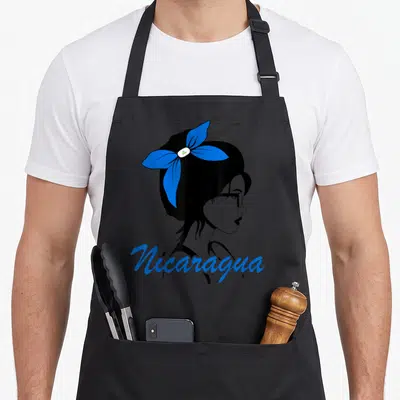 Nicarague nicaraguan girl apron - Minimalist woman profile with blue bow and Nicaragua script text — shown on a black cotton canvas apron against a white background