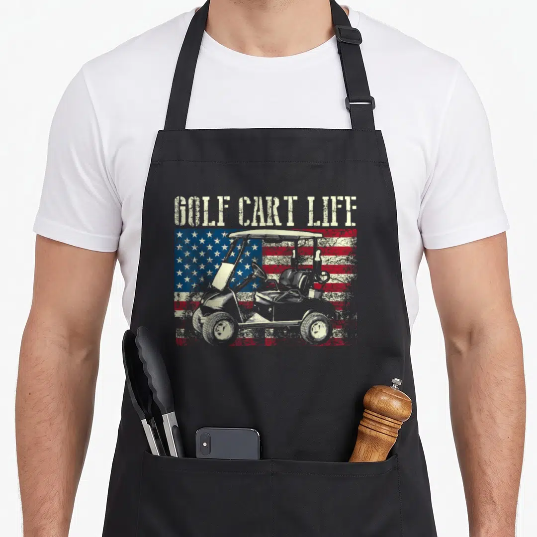 Cart flag golf apron - GOLF CART LIFE text over distressed USA flag and golf cart illustration — shown on a black cotton canvas apron against a white background