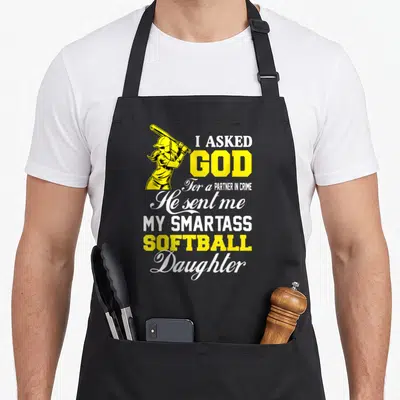 Smartass mom daughter apron - Yellow softball batter illustration next to white and yellow stacked text reading I asked — shown on a black cotton canvas apron against a white background