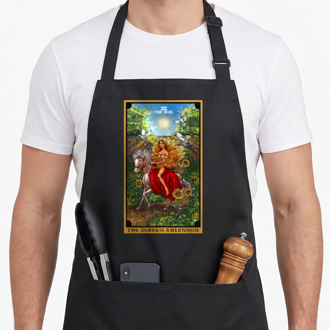 Rhiannon witch apron - Goddess Rhiannon riding white horse with flying doves and sunflowers under gold border — shown on a black cotton canvas apron against a white background