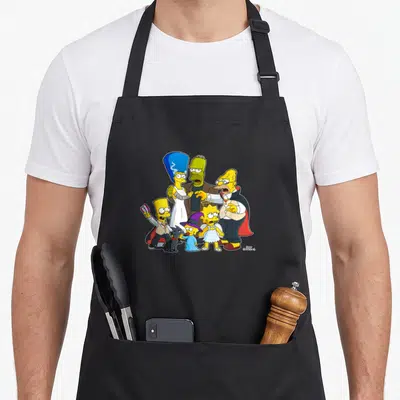 Family halloween apron - Simpsons family in Halloween costumes including vampire, mummy, witch, angel, and black cat — shown on a black cotton canvas apron against a white background
