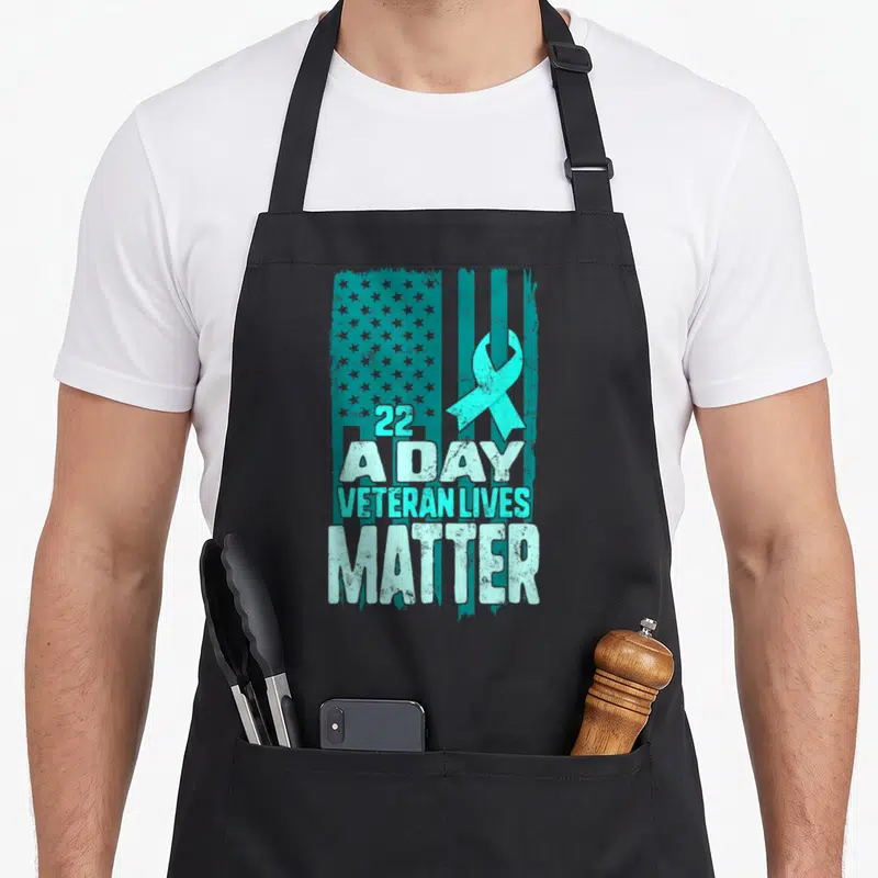 Live american flag apron - Teal distressed US flag with white text 22 A DAY VETERAN LIVES MATTER and teal awareness — shown on a black cotton canvas apron against a white background