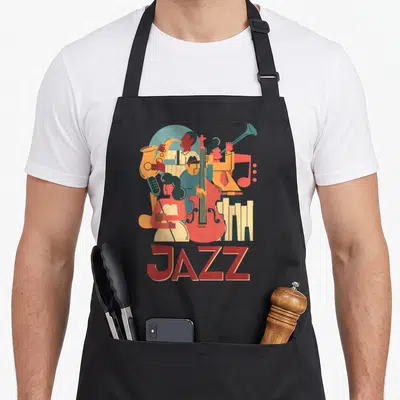 Musician jazz apron - Retro illustration of musicians with sax, bass, piano and trombone in red tan blue yellow above — shown on a black cotton canvas apron against a white background