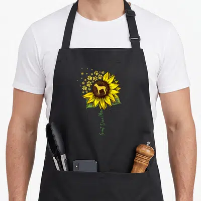 Sunflower dog apron - Yellow sunflower with dog silhouette and vertical Great Dane Mom text — shown on a black cotton canvas apron against a white background