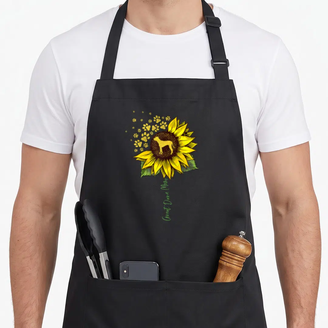 Sunflower dog apron - Yellow sunflower with dog silhouette and vertical Great Dane Mom text — shown on a black cotton canvas apron against a white background