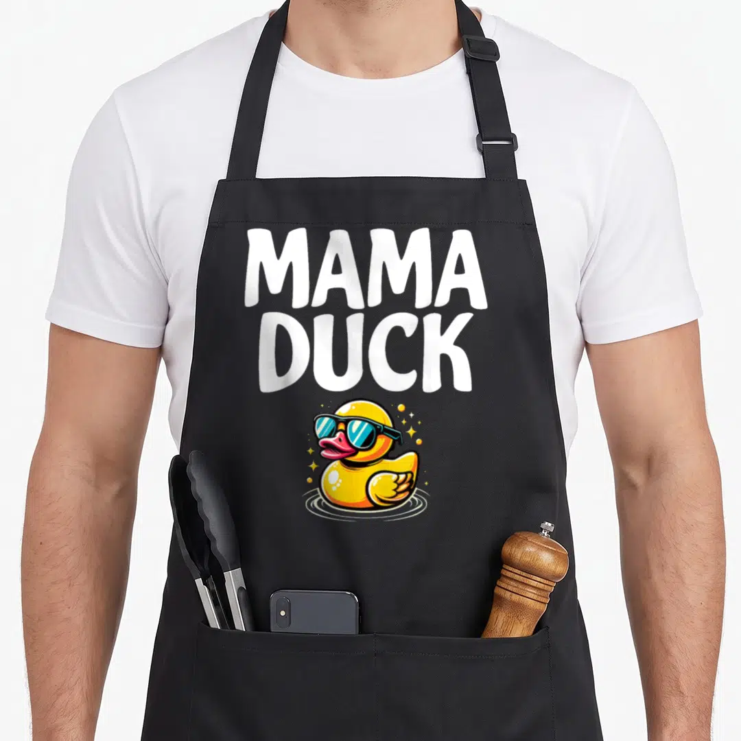Retro duck rubber apron - MAMA DUCK text above yellow rubber duck with blue sunglasses in water — shown on a black cotton canvas apron against a white background
