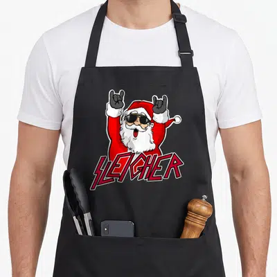 Metal santa claus apron - Cartoon Santa with sunglasses making rock horns above SLEIGHER text in red and black — shown on a black cotton canvas apron against a white background