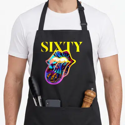 Sixty rolling stones apron - Yellow SIXTY text above multicolored mouth and tongue in cartoon style — shown on a black cotton canvas apron against a white background