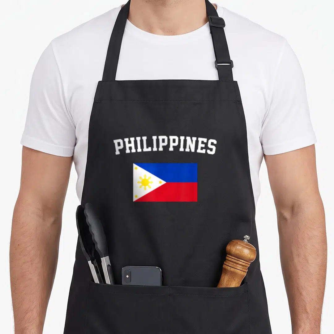Filipino flag pride apron - Arched PHILIPPINES text above blue red and yellow flag on canvas — shown on a black cotton canvas apron against a white background