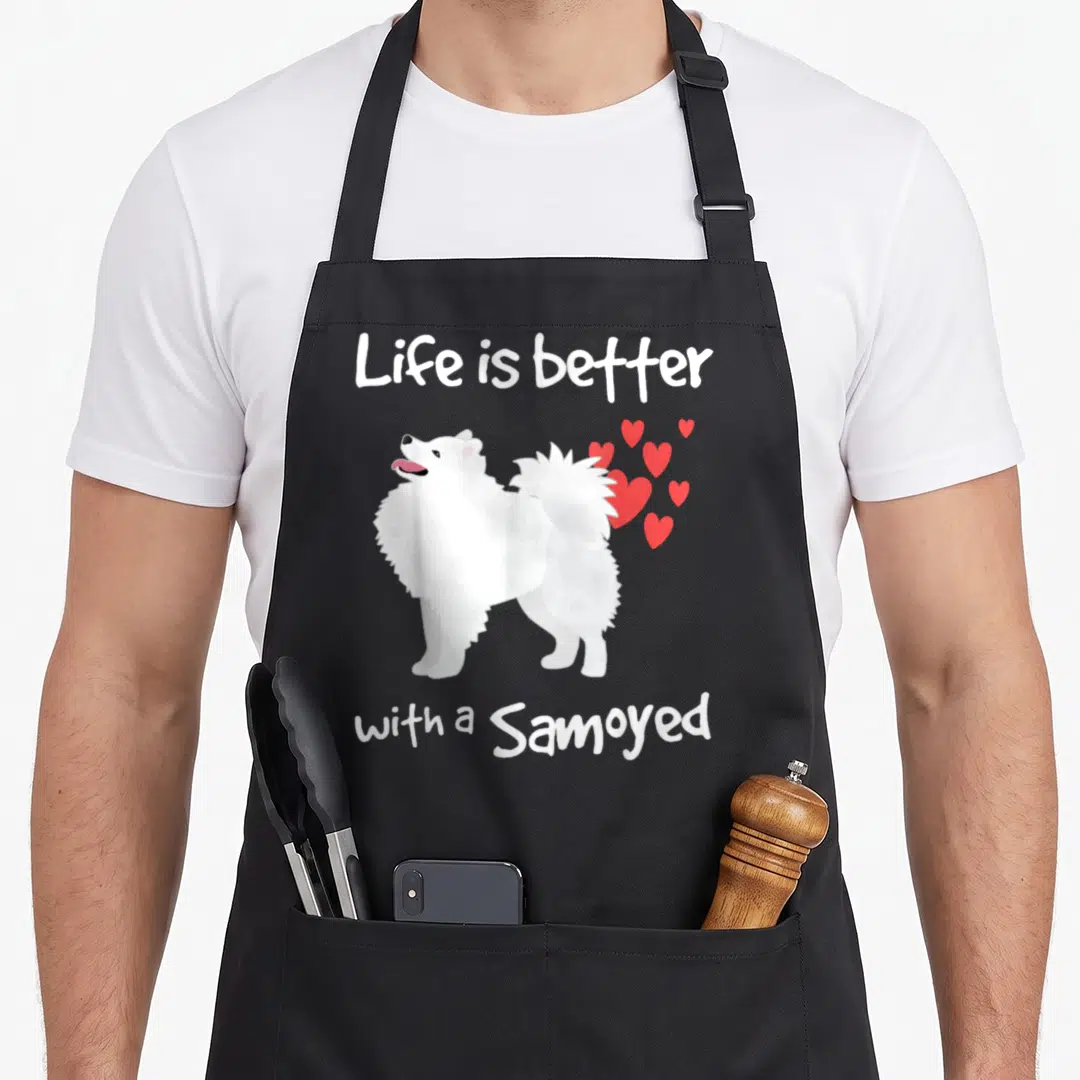 Better class life apron - White cartoon Samoyed centered between text with red hearts cluster on right — shown on a black cotton canvas apron against a white background