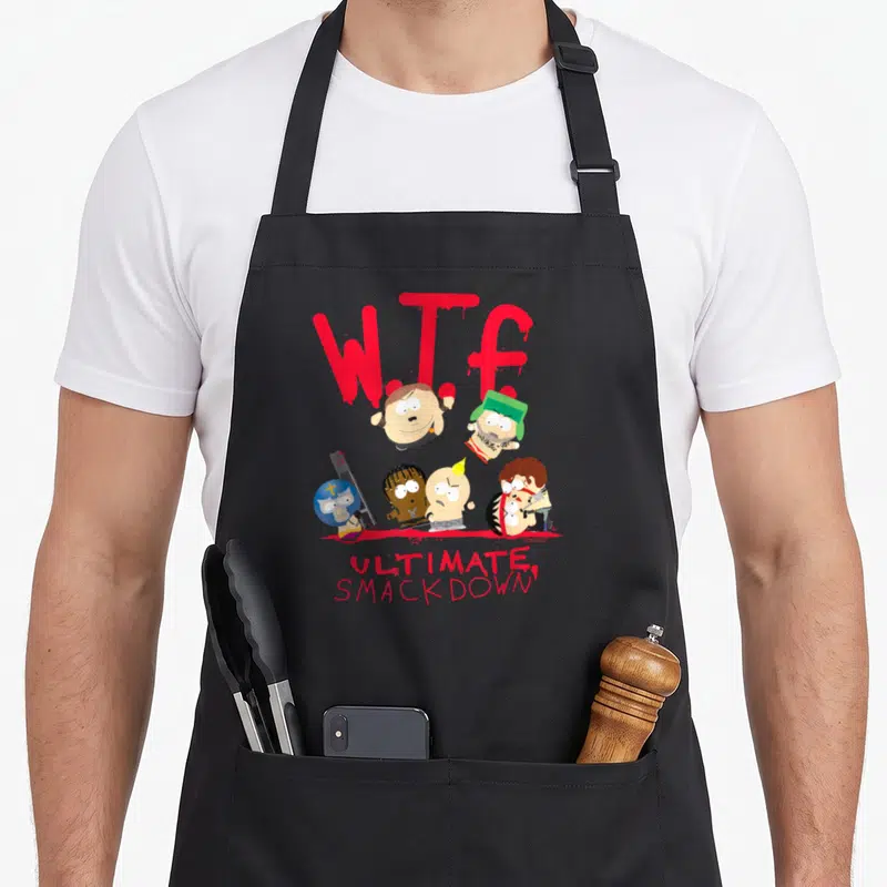Smackdown ultimate apron - W.T.F text above five cartoon wrestlers with one holding a knife, ULTIMATE SMACKDOWN below — shown on a black cotton canvas apron against a white background