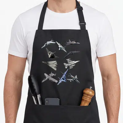F22 military f l co apron - Nine fighter jets in grey white and blue photo style scattered across front panel — shown on a black cotton canvas apron against a white background