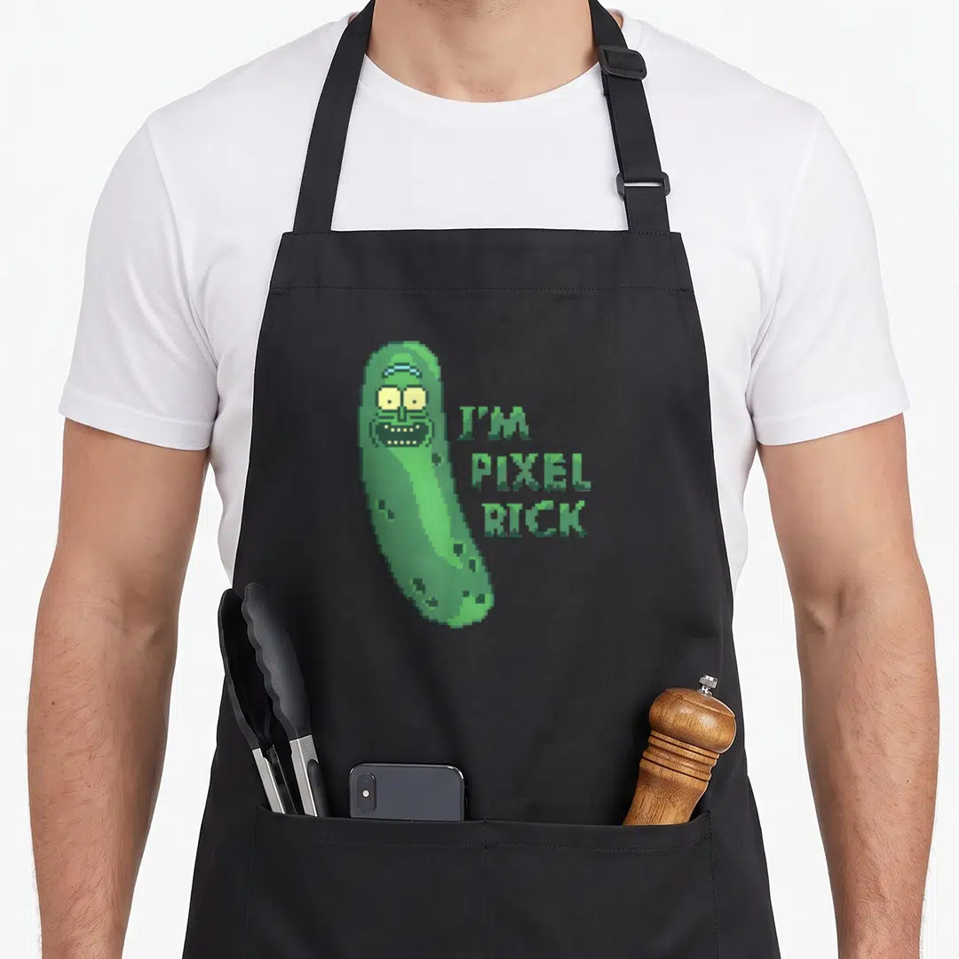 Pixel pickle apron - Green pixelated pickle character beside stacked I'M PIXEL RICK text in 8-bit font — shown on a black cotton canvas apron against a white background