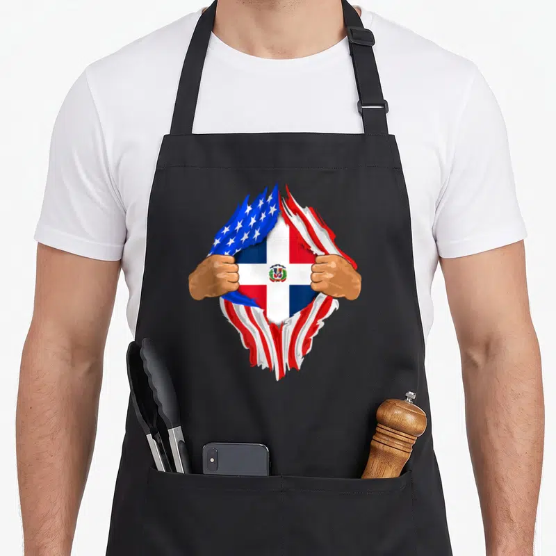 Dominican blood apron - Hands tearing surface to show USA and Dominican Republic flags in red white blue — shown on a black cotton canvas apron against a white background