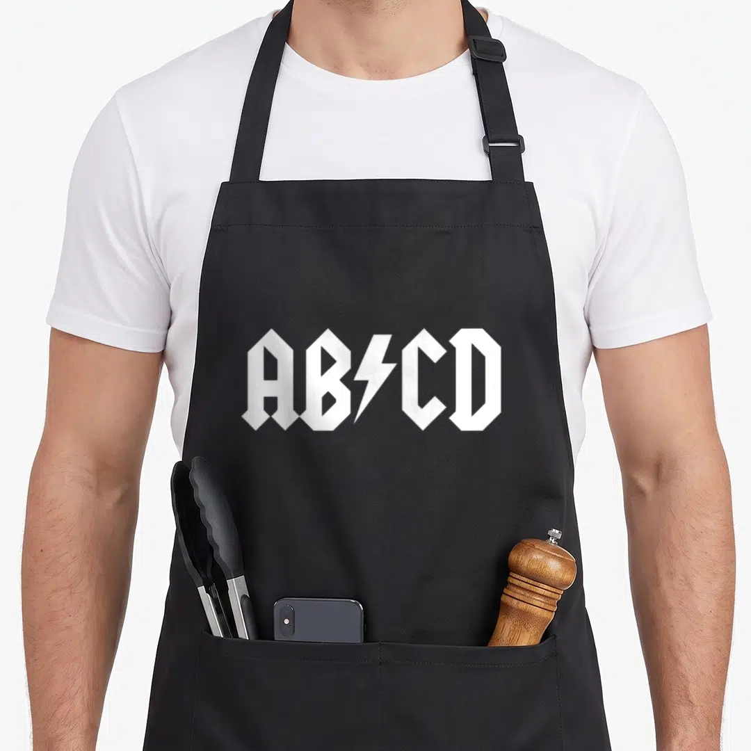 Abcd teacher apron - White AB⚡CD gothic typography with lightning bolt symbol — shown on a black cotton canvas apron against a white background