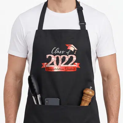 Class congratulation apron - Red and white rhinestone 2022 numbers with graduation cap and red ribbon text — shown on a black cotton canvas apron against a white background