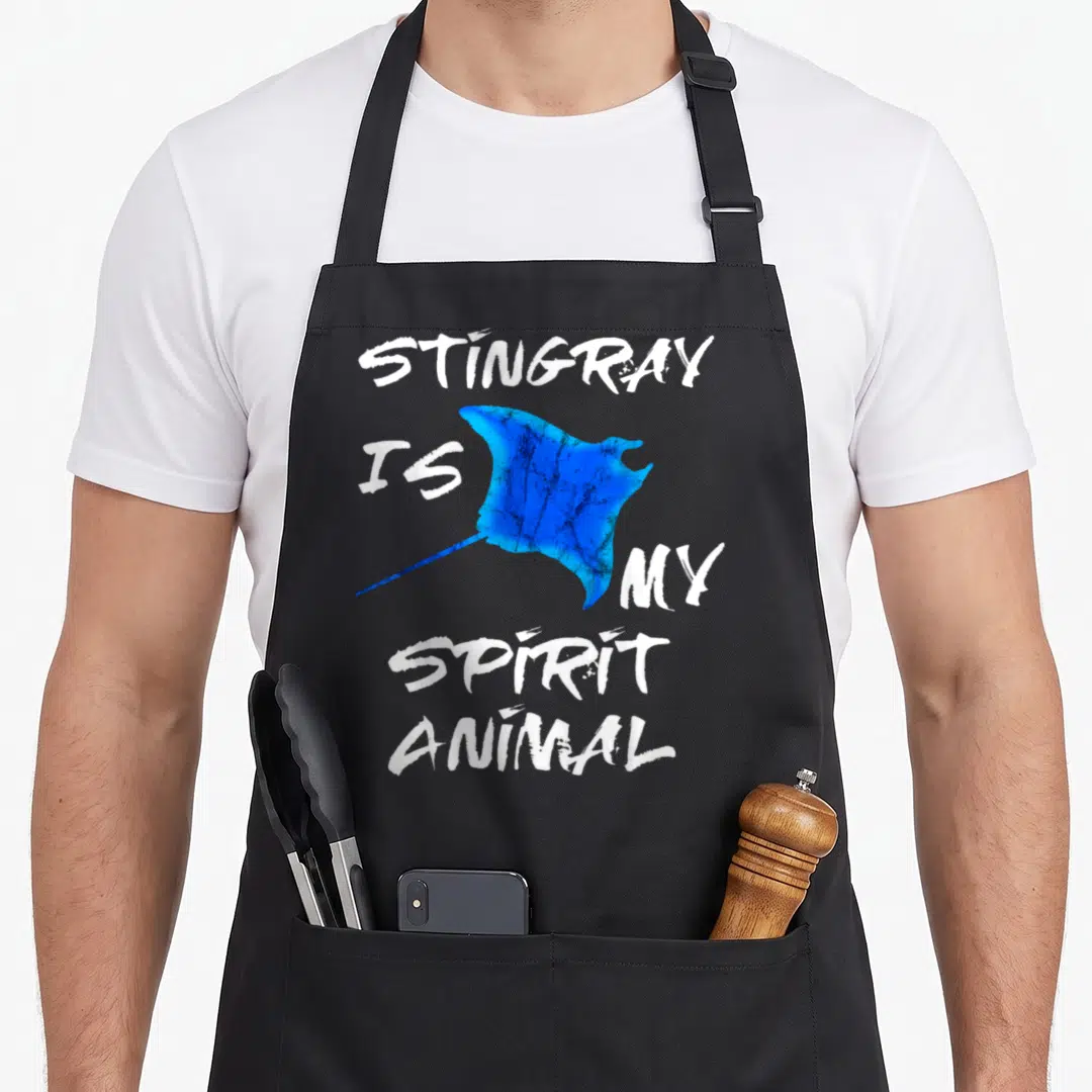 Ray animal apron - Blue stingray graphic surrounded by white distressed text STINGRAY IS MY SPIRIT ANIMAL — shown on a black cotton canvas apron against a white background