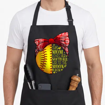 Softball outfielder apron - Yellow softball with red paisley bow and yellow text reading THIS MOM LOVES HER SOFTBALL — shown on a black cotton canvas apron against a white background