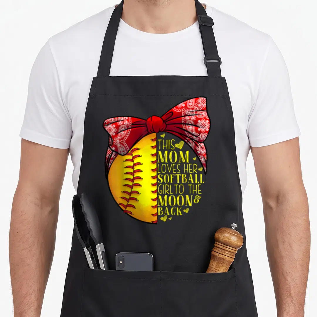 Softball outfielder apron - Yellow softball with red paisley bow and yellow text reading THIS MOM LOVES HER SOFTBALL — shown on a black cotton canvas apron against a white background