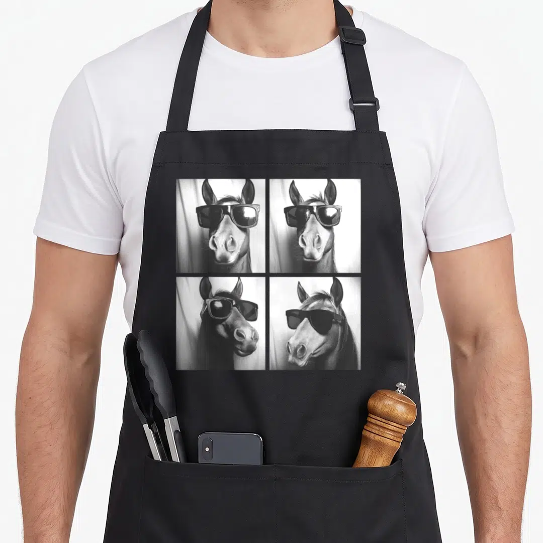 Sunglass farm apron - Four black and white photos of horse heads wearing sunglasses in a grid — shown on a black cotton canvas apron against a white background