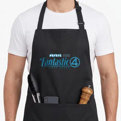 Four first steps apron - Blue and white stacked text reading Marvel Studios Fantastic 4 First Steps with circled number — shown on a black cotton canvas apron against a white background