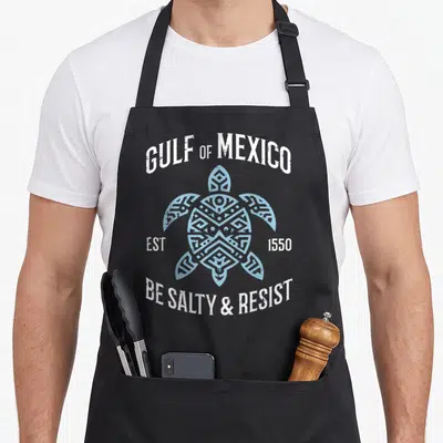 Resist mexico apron - Distressed sea turtle graphic with arched text GULF OF MEXICO and BE SALTY RESIST — shown on a black cotton canvas apron against a white background