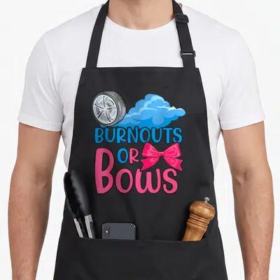 Reveal bow apron - Silver car wheel blue cloud BURNOUTS OR BOWS text pink bow cartoon style — shown on a black cotton canvas apron against a white background