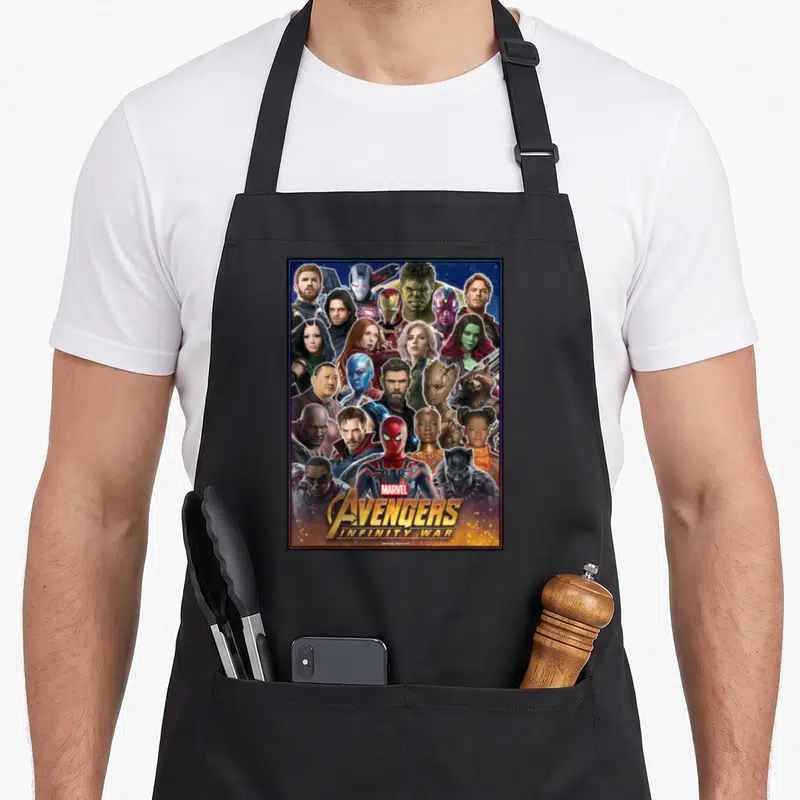 Headshot infinity apron - Collage of superhero faces in blue, gold, and red with stacked Marvel Avengers Infinity War — shown on a black cotton canvas apron against a white background