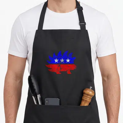 Freedom porcupine apron - Distressed hedgehog silhouette in blue and red with three white stars — shown on a black cotton canvas apron against a white background