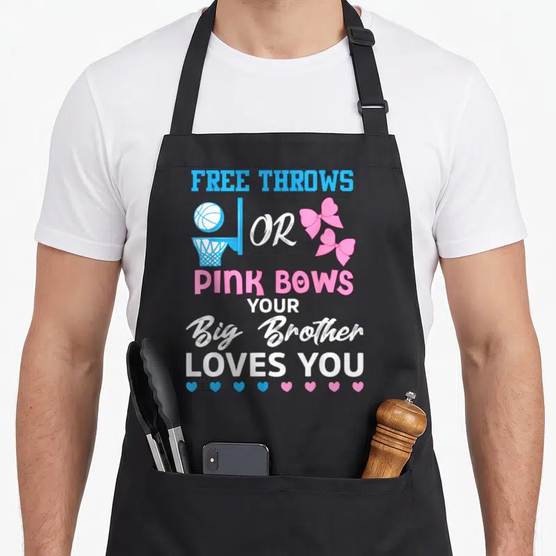 Brother bow apron - Stacked text free throws or pink bows with basketball hoop and two pink bows above alternating — shown on a black cotton canvas apron against a white background