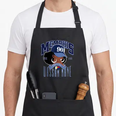 Hometown memphis apron - Cartoon woman with afro and 901 cap surrounded by Memphis text and Wassam Mane ribbon in blue — shown on a black cotton canvas apron against a white background