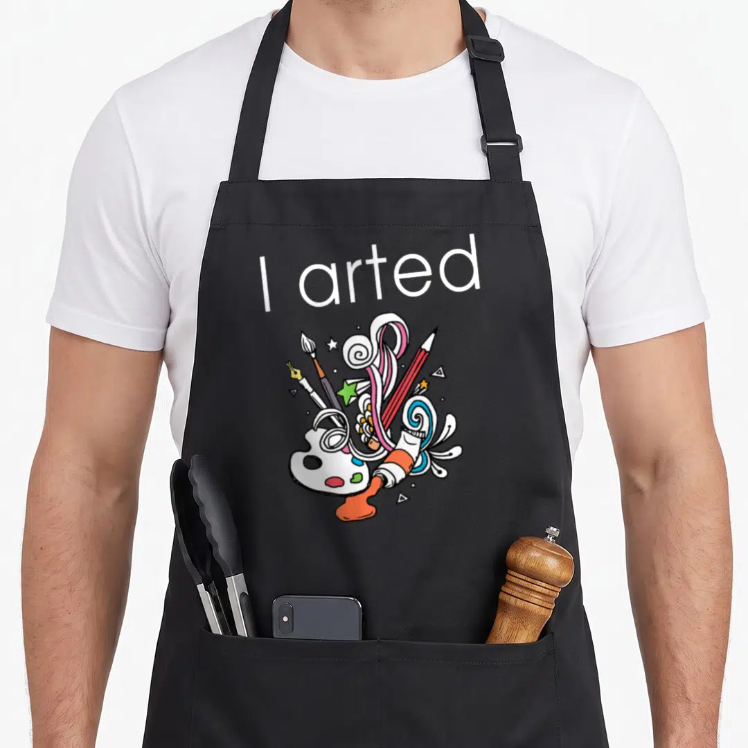 Arted colored aprons - I arted text above cartoon art supplies and colorful swirls — shown on a black cotton canvas apron against a white background