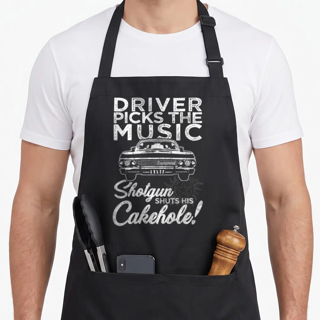 Pick driver apron - White distressed car with text DRIVER PICKS THE MUSIC and a pentagram sun symbol — shown on a black cotton canvas apron against a white background