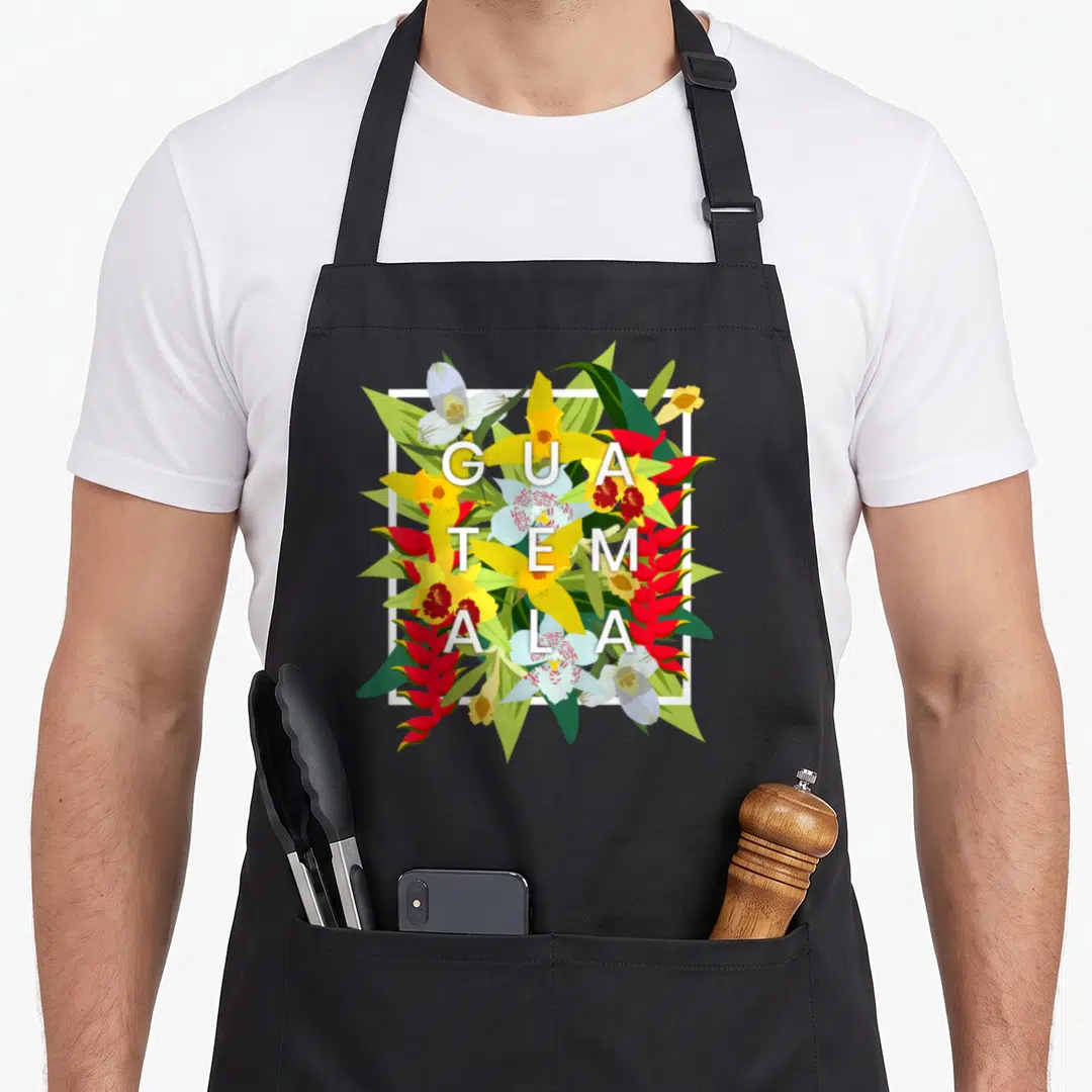 Flower guatemala guatemalan aprons - Stacked GUA TEM ALA text over yellow red and green tropical flowers in white frame — shown on a black cotton canvas apron against a white background