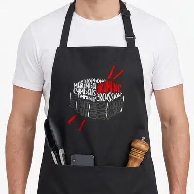 Drumline marching band apron - Typography drum shape formed by words xylophone marimba snare quads with two red sticks — shown on a black cotton canvas apron against a white background