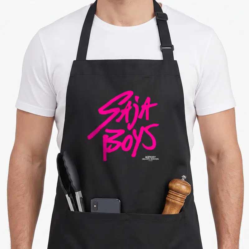 Funny saja trend apron - Pink SAJA BOYS stacked script text with small Kpop Demon Hunters logo watermark — shown on a black cotton canvas apron against a white background