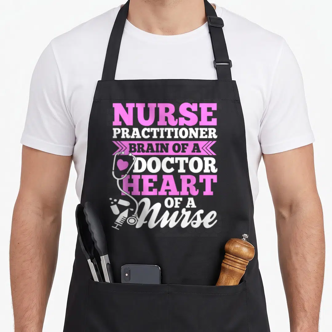 Practitioner nurse apron - Pink and white stacked text reading Brain of a Doctor Heart of a Nurse with a stethoscope — shown on a black cotton canvas apron against a white background