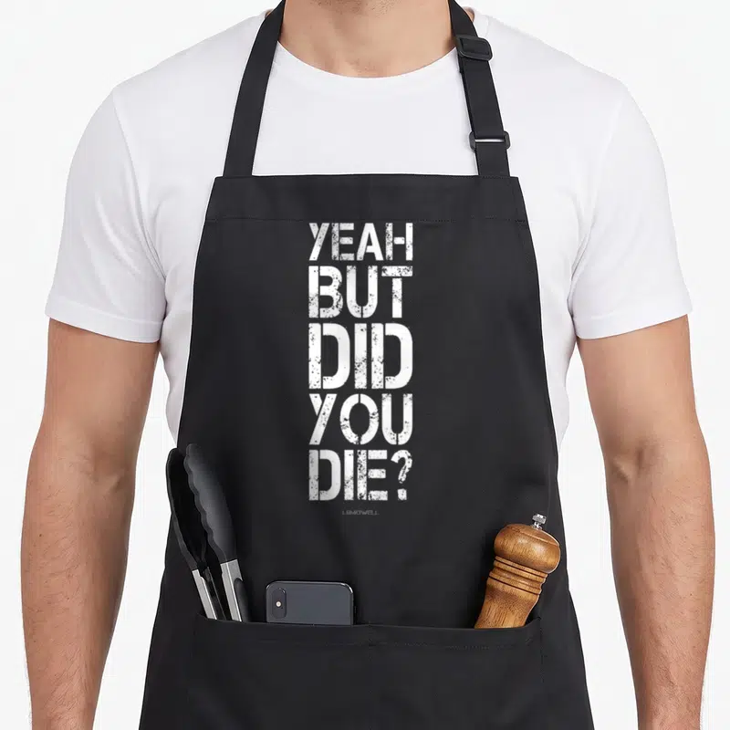 But yeah love apron - White distressed stacked text reading YEAH BUT DID YOU DIE on grey background — shown on a black cotton canvas apron against a white background