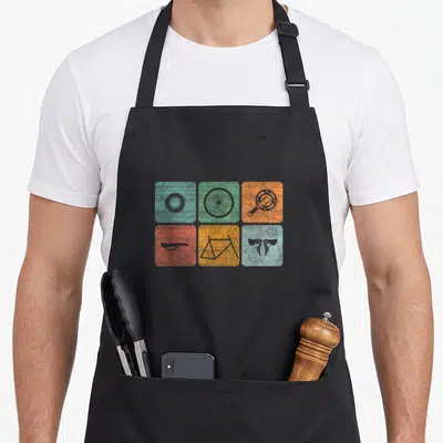 Biking cycling apron - Six colored squares with grey bicycle part silhouettes in a grid — shown on a black cotton canvas apron against a white background