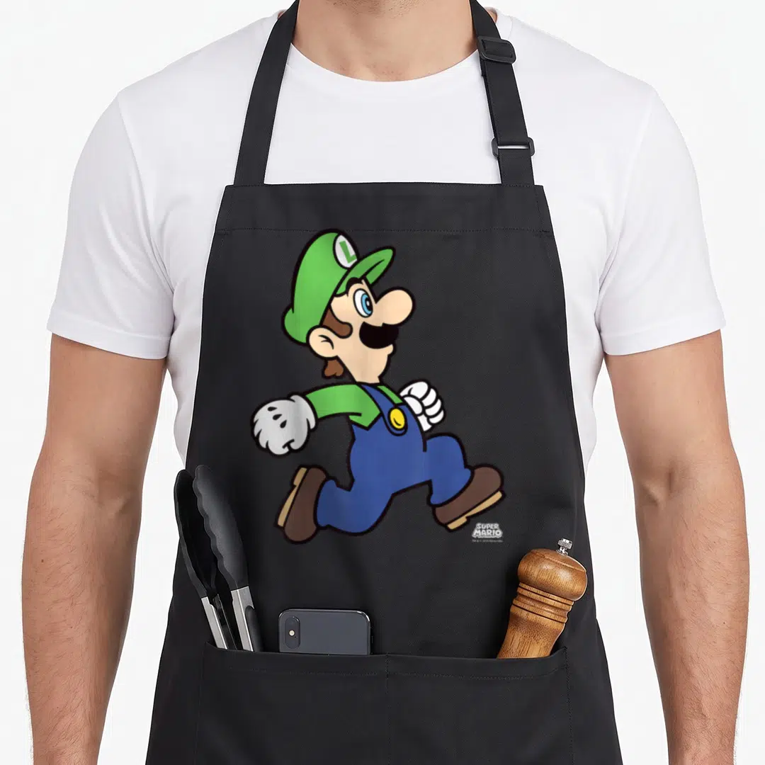 Run holiday apron - Luigi running in green and blue with SUPER MARIO logo text — shown on a black cotton canvas apron against a white background