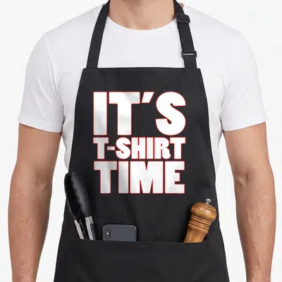 Gym laundry apron - Stacked white text with red outlines reading IT'S T-SHIRT TIME — shown on a black cotton canvas apron against a white background